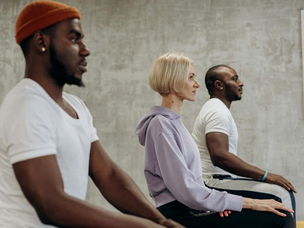 Group of diverse people sitting together on yoga mats.